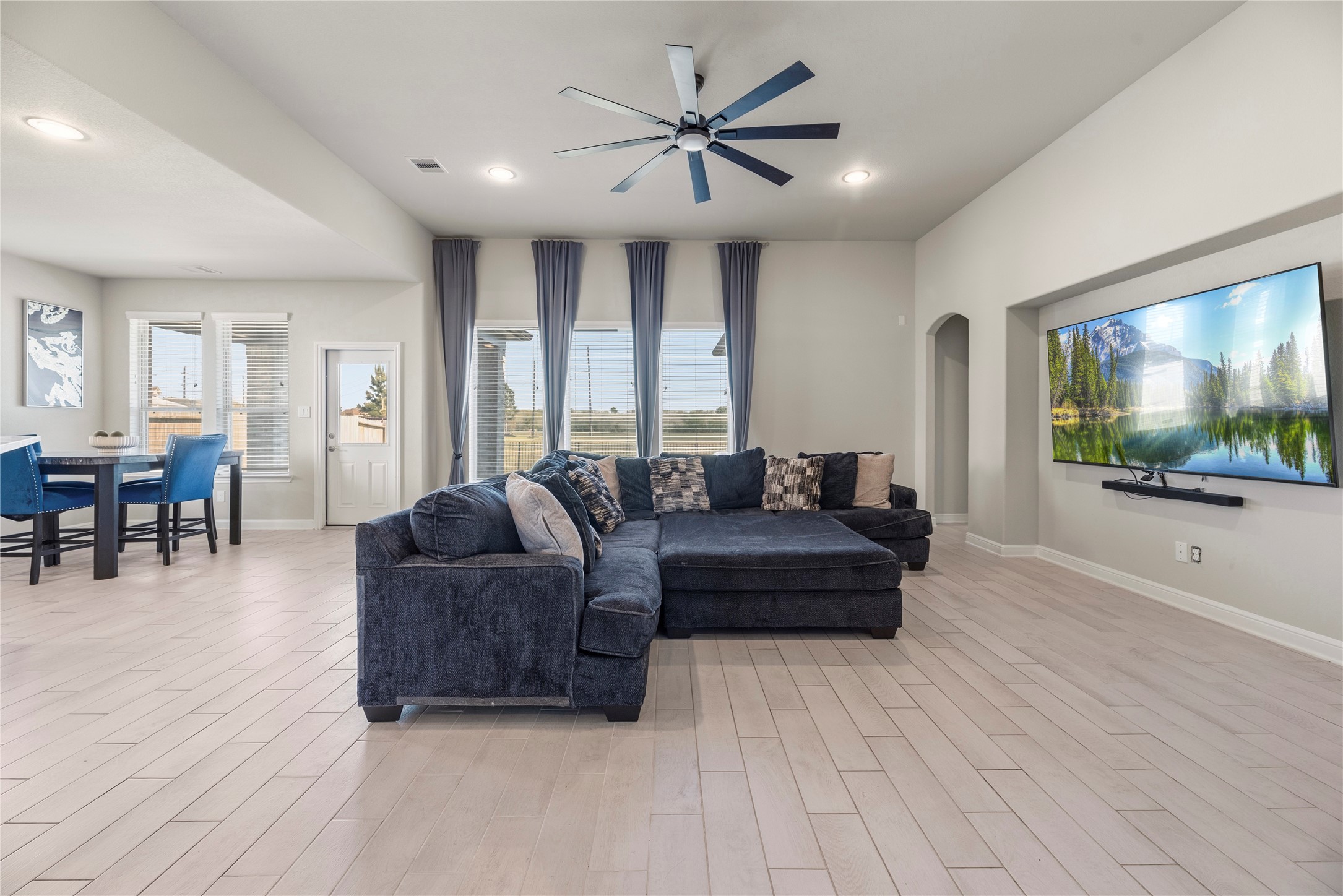 3319 Learning Tree Lane Rosenberg, TX 77471 - Photo 9 of 44 Bask in the natural light and captivating backyard views from the family room's expansive windows, creating a serene and inviting atmosphere.