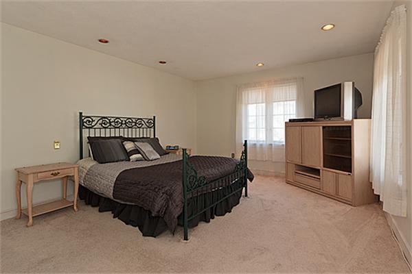 14 Apache Trail Arlington, MA 02474 - Photo 19 of 29 a spacious bedroom with a bed and a television in it