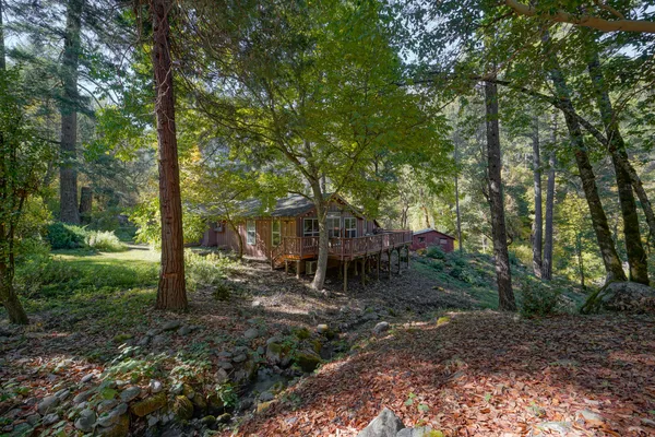 a kitchen with stainless steel appliances granite countertop a refrigerator a stove top oven a sink and dishwasher with wooden floor