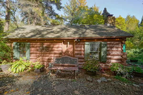 a backyard of a house with a tree and outdoor seating