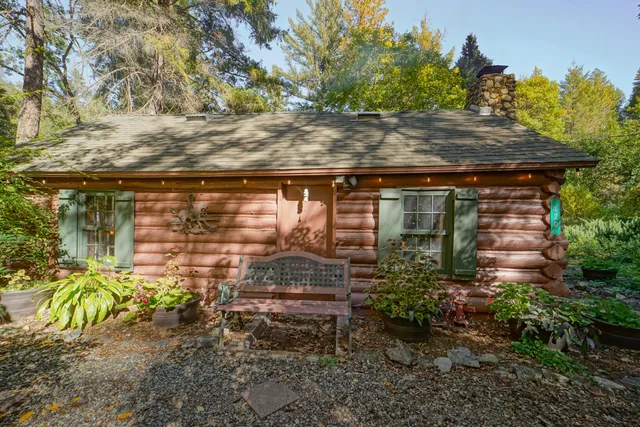a backyard of a house with a tree and outdoor seating