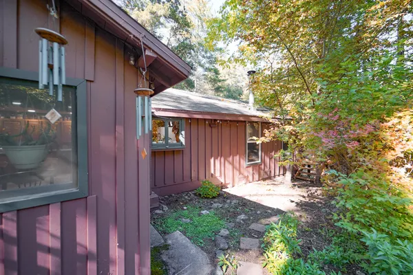 a view of a house with a small yard and large tree