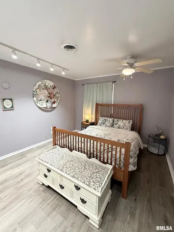 a bed sitting in a bedroom next to a window and a chandelier