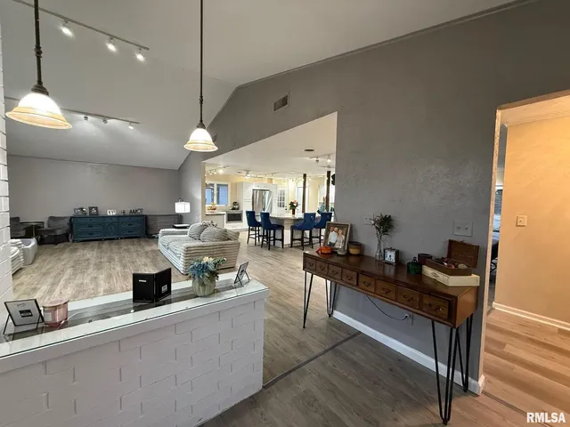 a kitchen with a stove a sink a counter space and living room view
