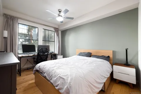 a bedroom with a bed a large window and flat screen tv