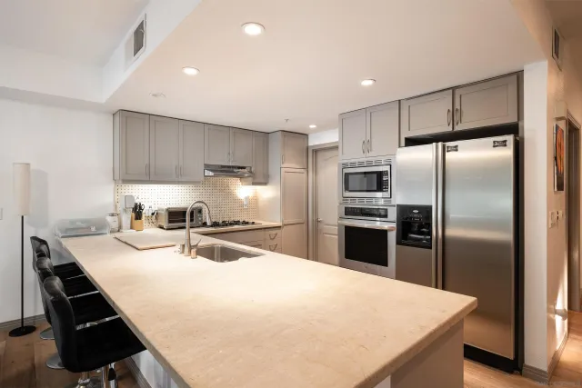a kitchen with kitchen island a refrigerator sink and stove