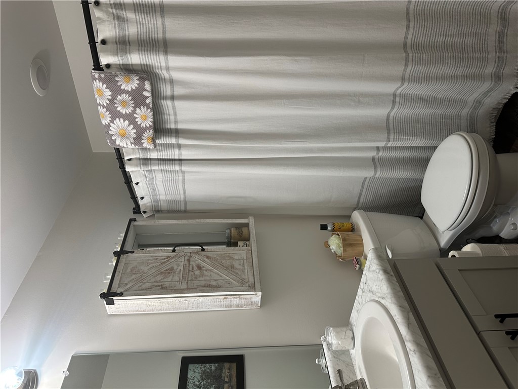 505 Blue Ridge Avenue Belton, SC 29627 - Photo 12 of 17 This bathroom features a contemporary vanity with a sleek sink and a classic toilet, offering functional elegance.