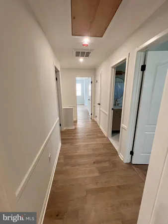 a view of a hallway with wooden floor and staircase