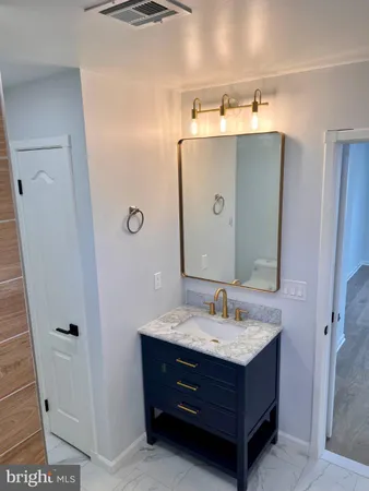 a bathroom with a sink vanity granite and a mirror