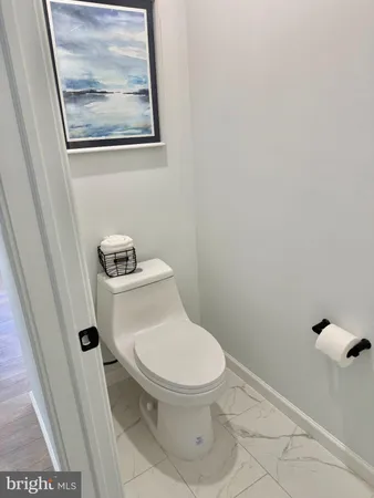 a white toilet sitting next to a small bathroom