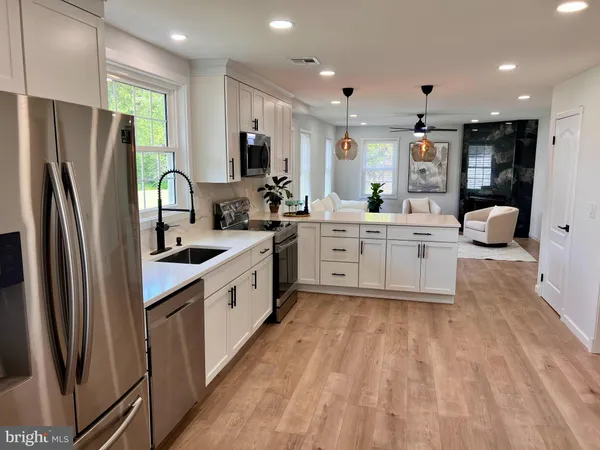 a large kitchen with stainless steel appliances lots of counter top space cabinets and a sink