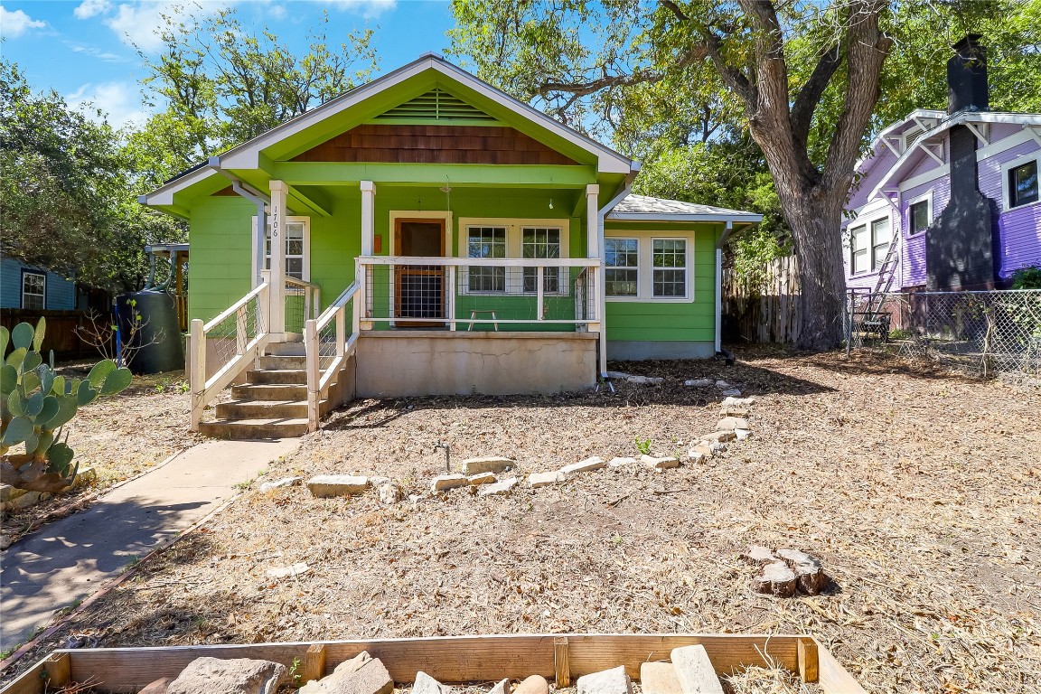 a front view of a house with a yard and potted plants