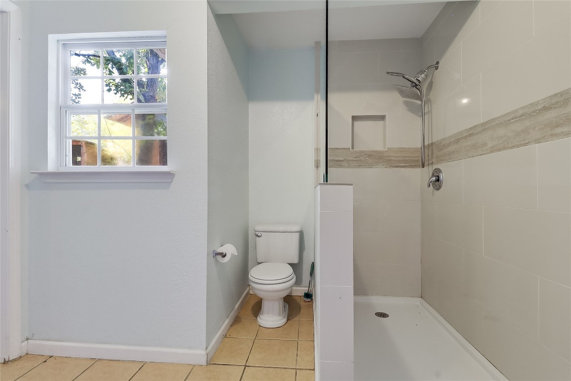 1706 Maple Avenue Austin, TX 78702 - Photo 11 of 30 a bathroom with a granite countertop toilet a sink and shower