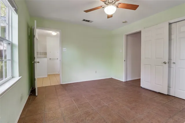 an empty room with fan and entrance