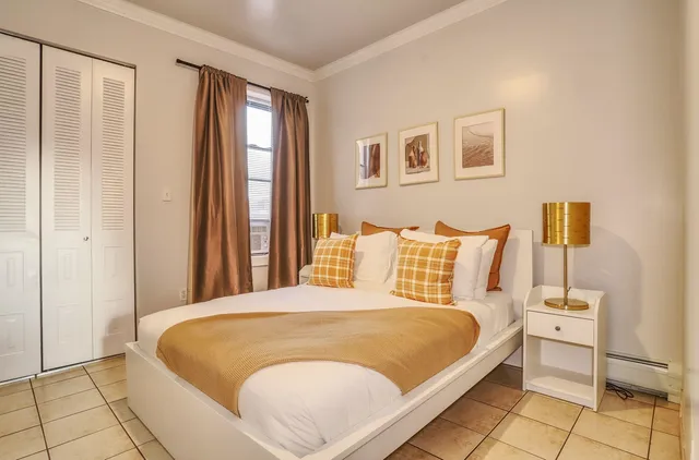 a large bed sitting in a bedroom next to a window and a lamp