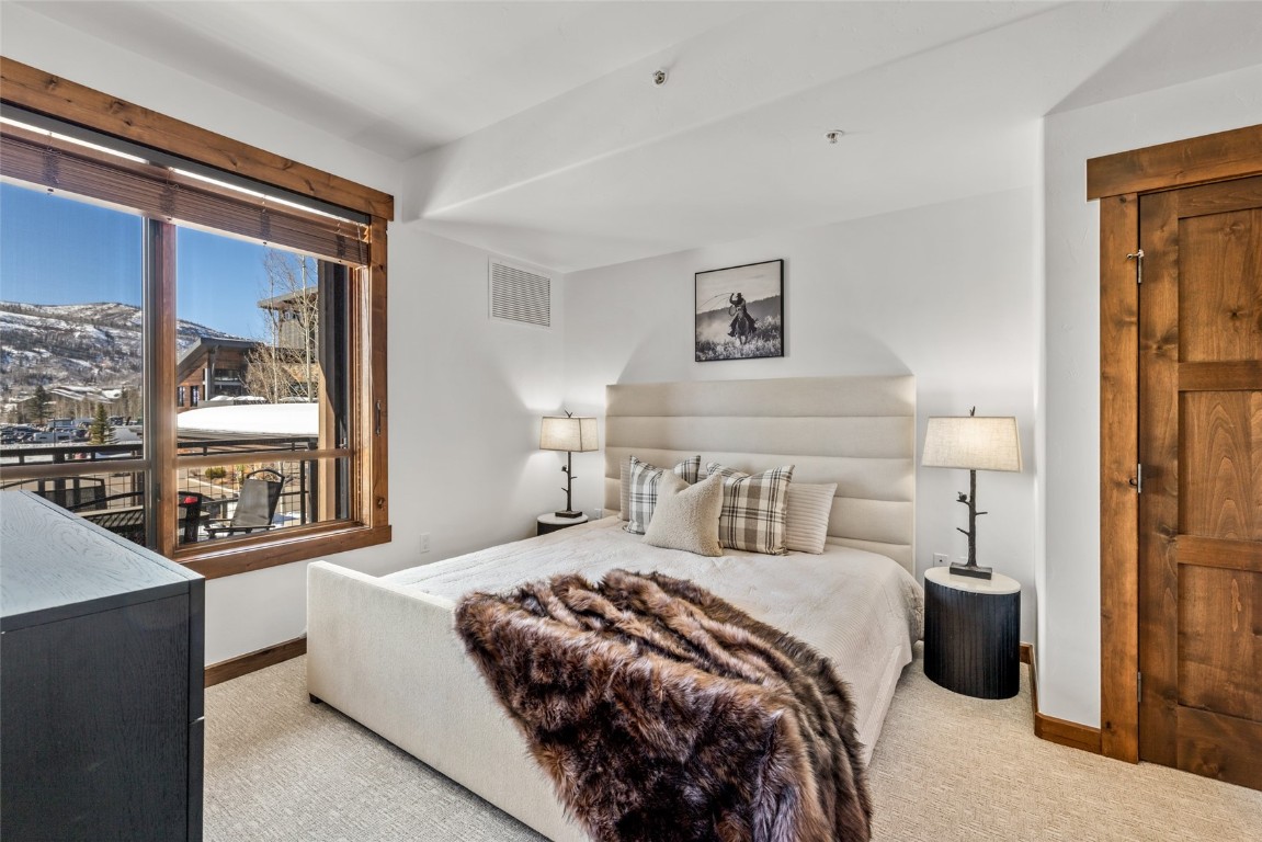 1175 Bangtail Way, Unit 2106 Steamboat Springs, CO 80487 - Photo 12 of 32 a bedroom with a bed and a large window