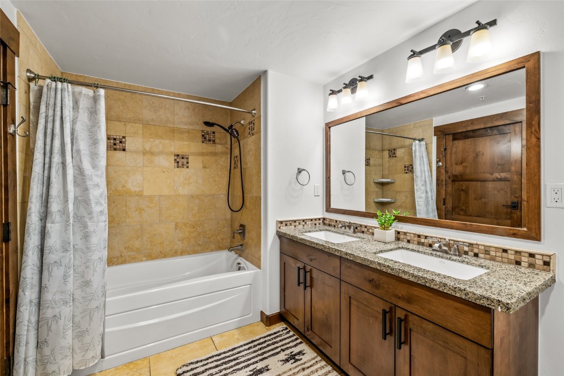 1175 Bangtail Way, Unit 2106 Steamboat Springs, CO 80487 - Photo 16 of 32 a bathroom with a granite countertop sink mirror and a bathtub