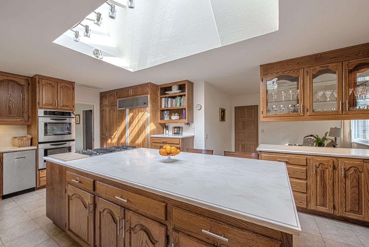 3048 Larkin Road Pebble Beach, CA 93953 - Photo 8 of 24 a kitchen with granite countertop a stove and cabinets