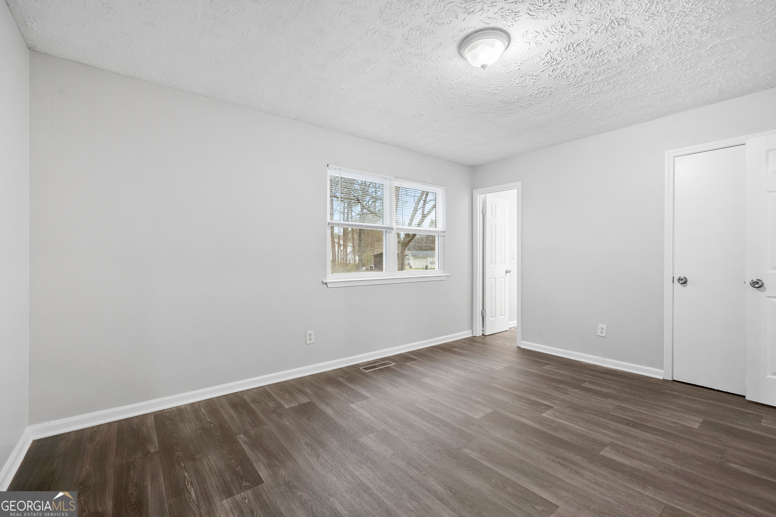 6155 Pointer Way Douglasville, GA 30135 - Photo 12 of 26 an empty room with wooden floor and windows