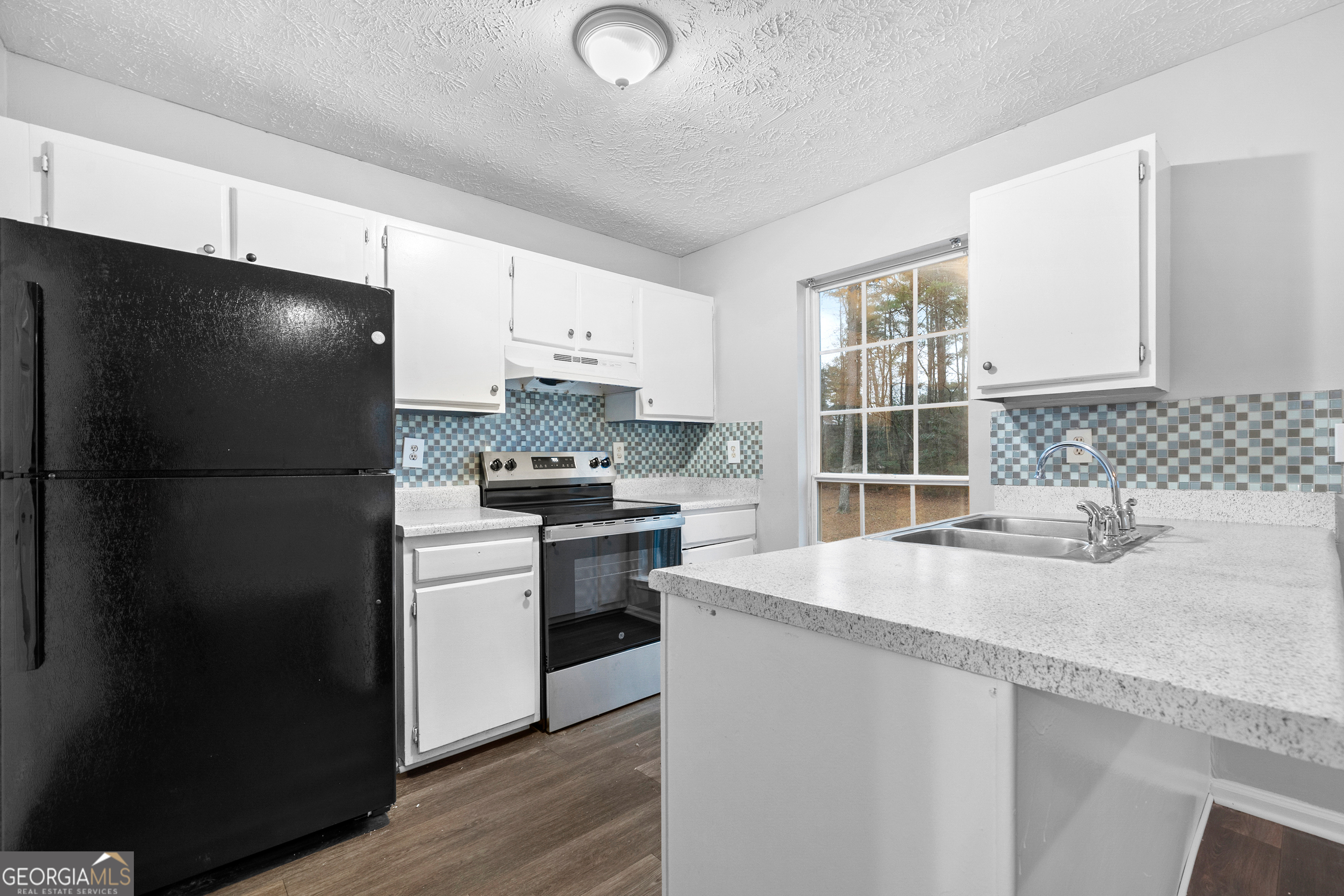 6155 Pointer Way Douglasville, GA 30135 - Photo 3 of 26 a kitchen with granite countertop a refrigerator stove and sink