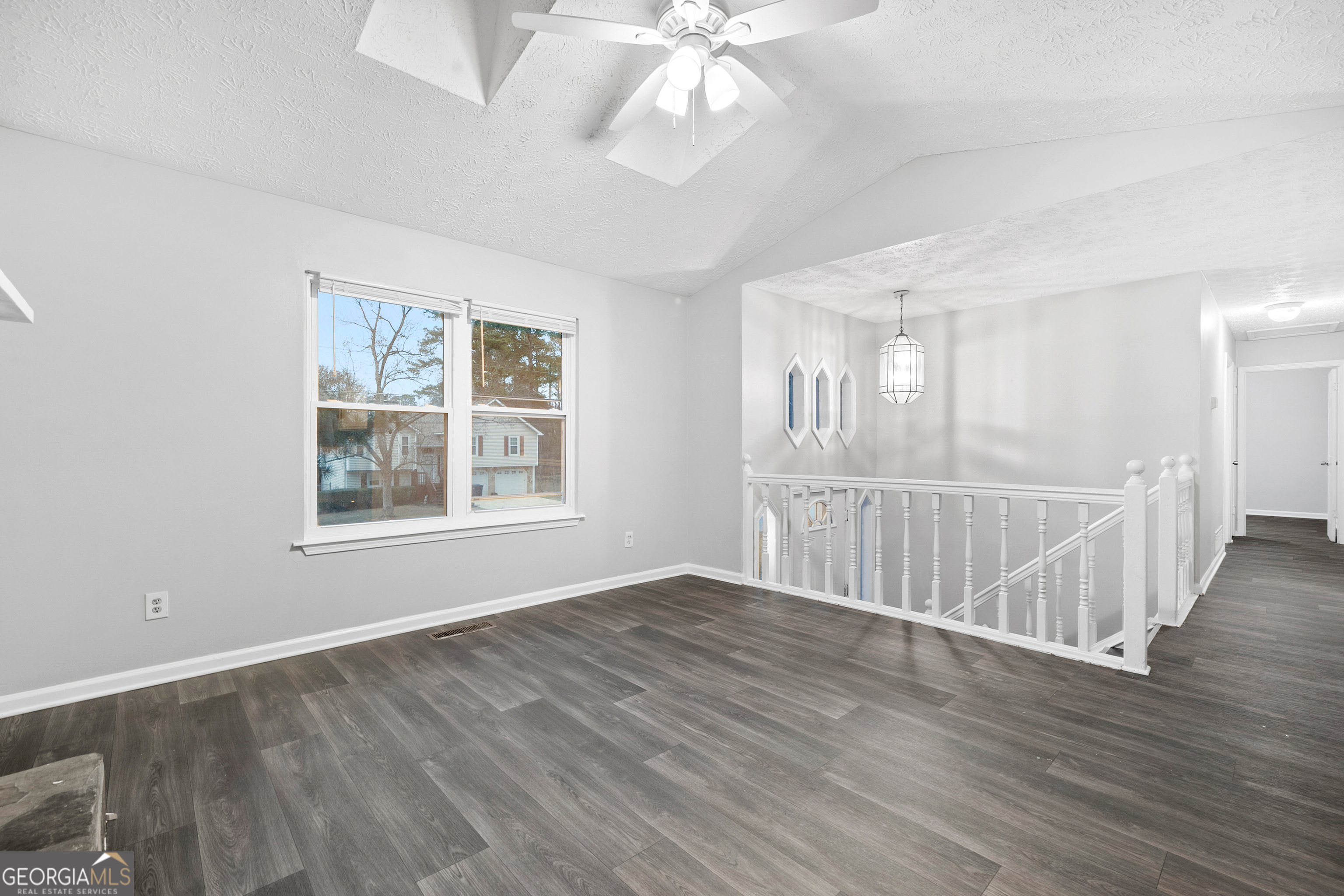 6155 Pointer Way Douglasville, GA 30135 - Photo 6 of 26 a view of an empty room with wooden floor and a window