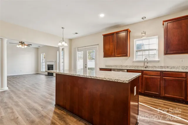 a large kitchen with granite countertop a sink dishwasher stove and cabinets