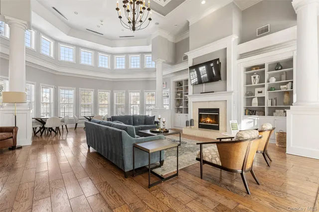 a living room with furniture a fireplace and a dining table with wooden floor