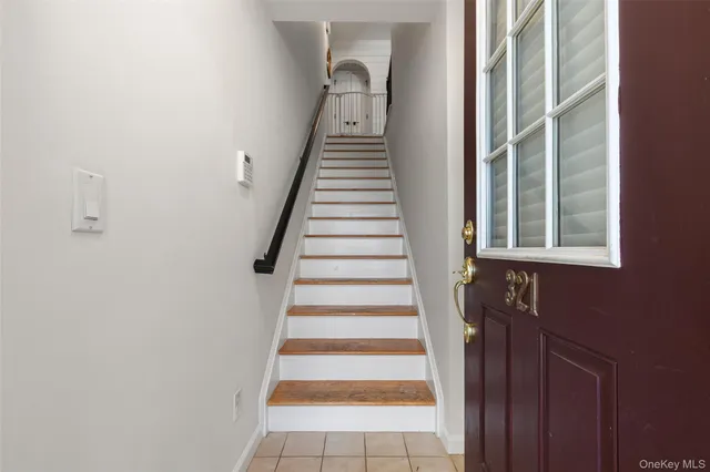 a view of a hallway with stairs and wooden floor