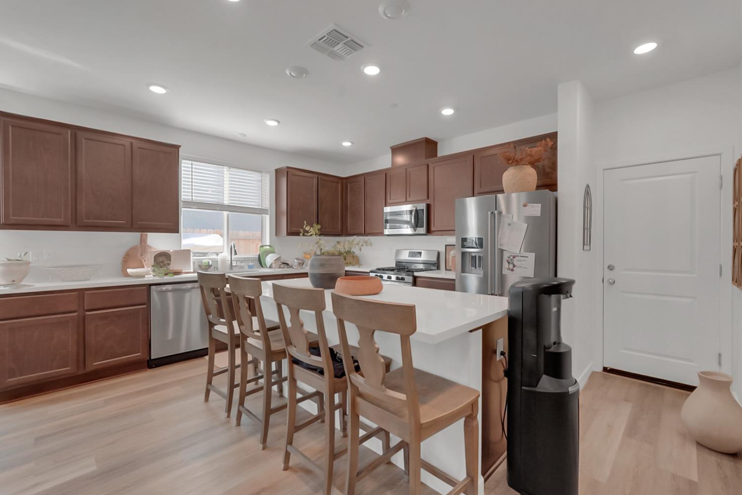 5518 Julia Avenue Keyes, CA 95328 - Photo 3 of 22 a kitchen with kitchen island granite countertop wooden floors and white cabinets