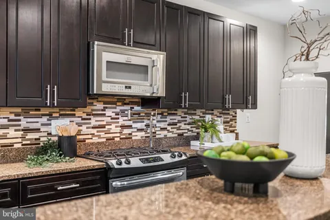 a room with wooden cabinets and stainless steel appliances