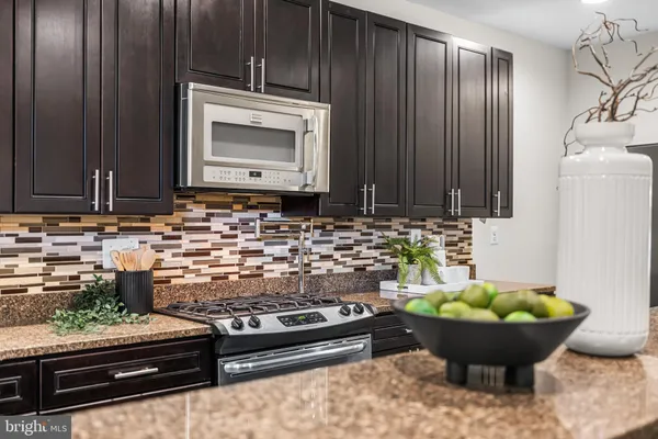a kitchen with stainless steel appliances granite countertop a sink stove and cabinets