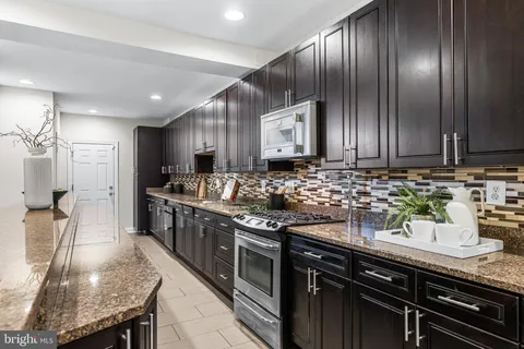 a kitchen with stainless steel appliances granite countertop a sink stove and cabinets