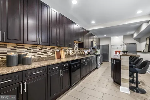 a kitchen with kitchen island granite countertop wooden cabinets a sink and stainless steel appliances