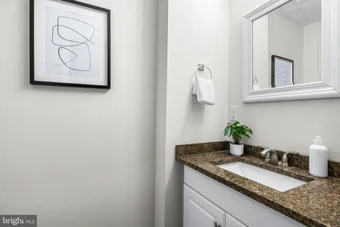 a bathroom with a granite countertop sink and a mirror
