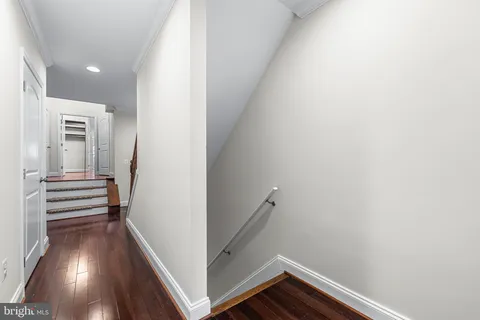 a view of hallway with stairs and wooden floor
