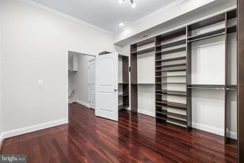 a view of empty room with wooden floor and electronic appliances