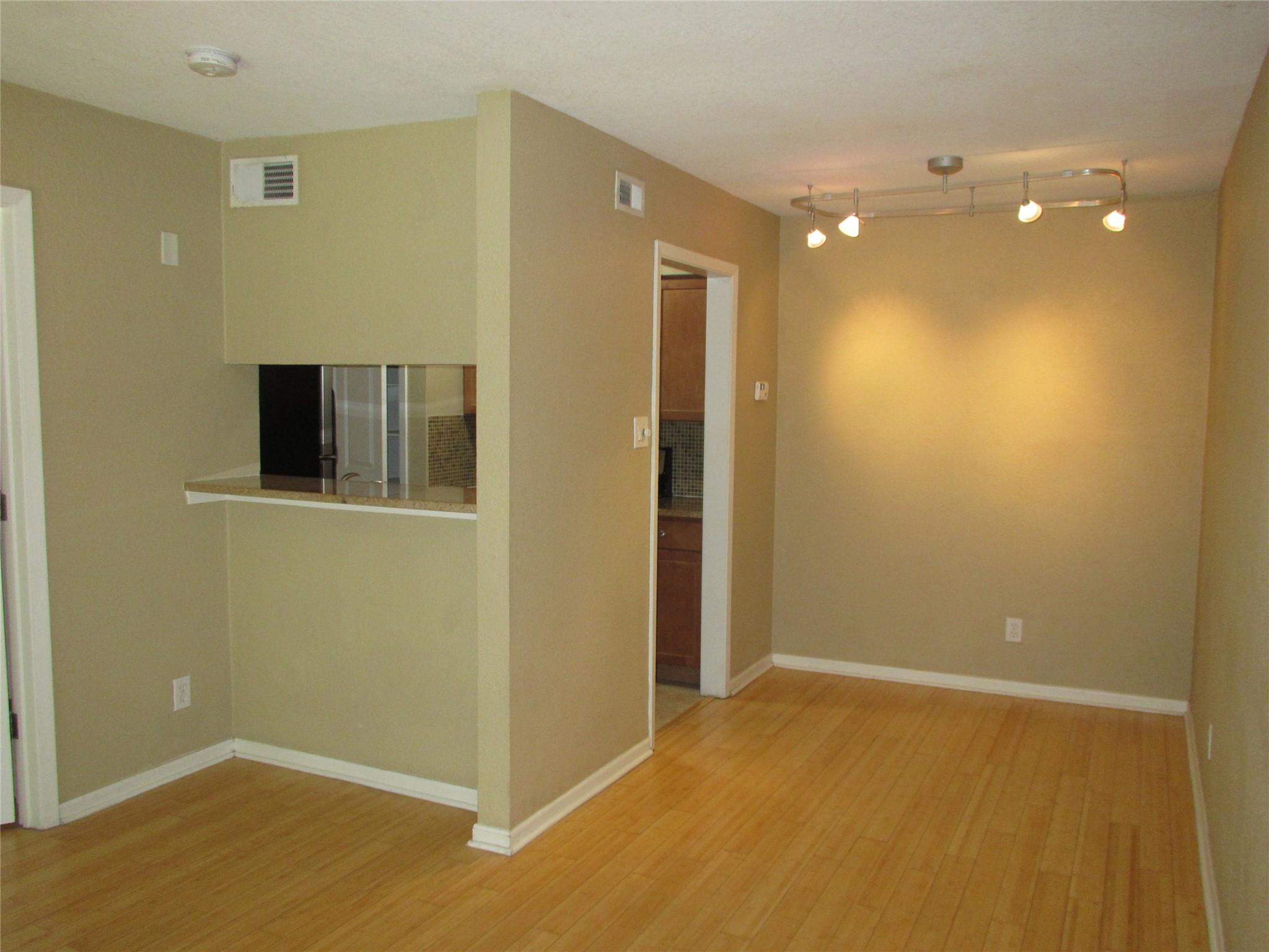 3204 Menchaca Road, Unit 702 Austin, TX 78704 - Photo 4 of 14 Spare room featuring light wood-type flooring, rail lighting, and a smoke detector