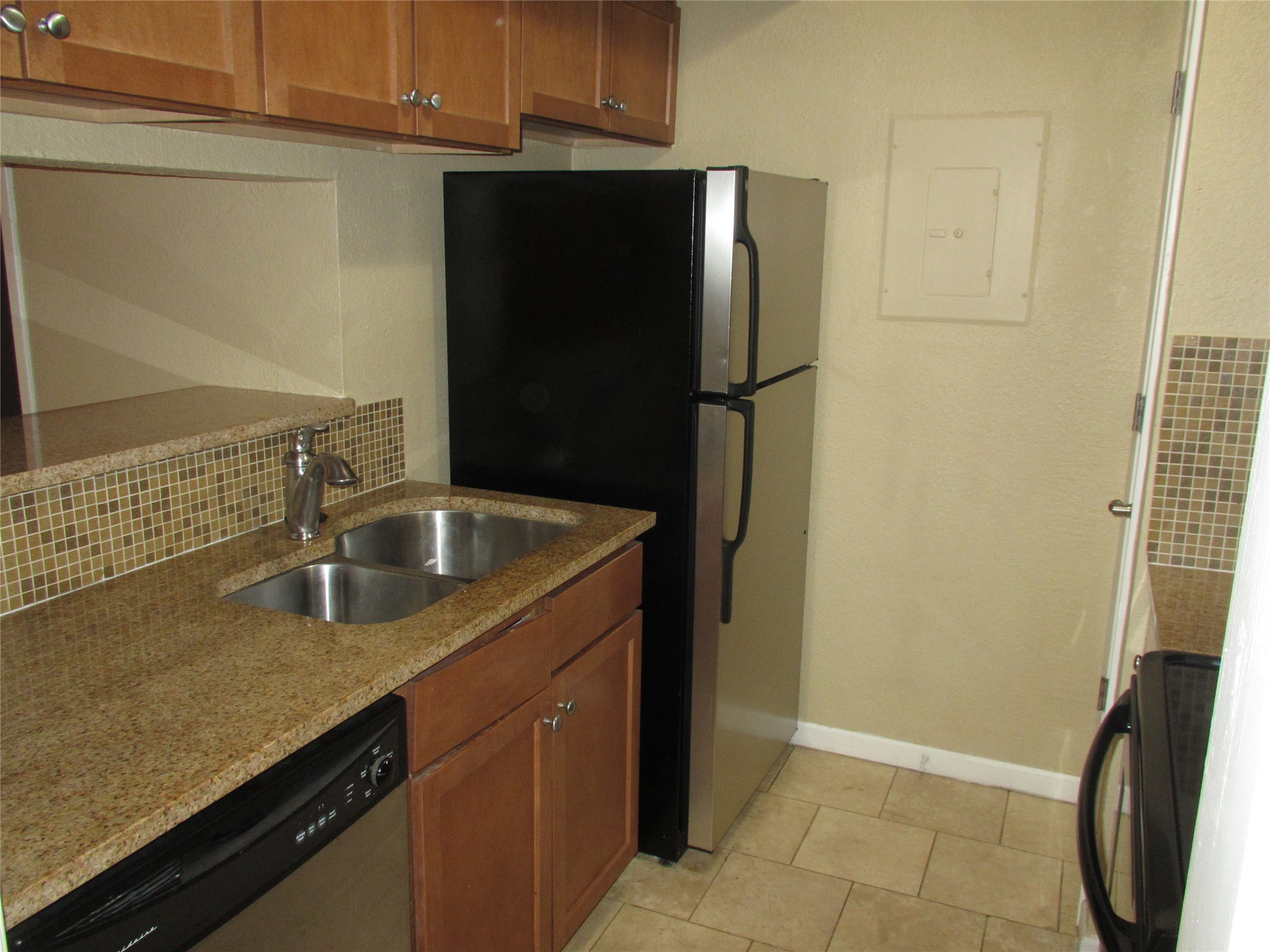 3204 Menchaca Road, Unit 702 Austin, TX 78704 - Photo 6 of 14 Kitchen featuring wood finish cabinets, stainless steel appliances, light stone counters, and electric panel