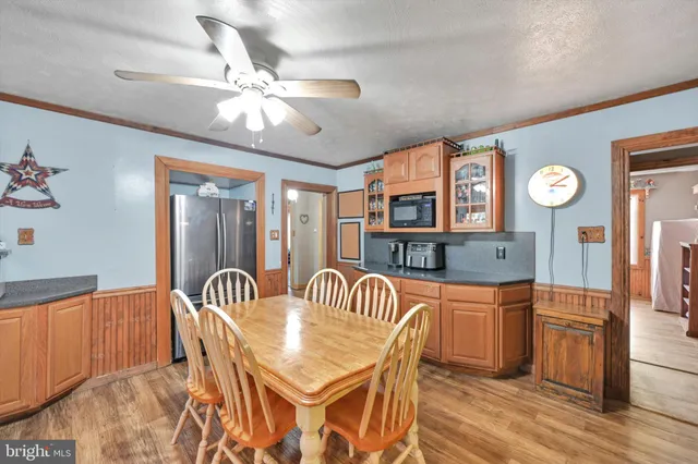 a view of a dining room with furniture and a chandelier fan