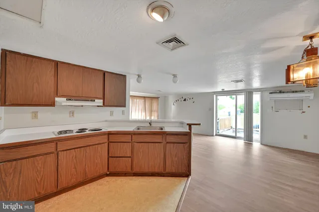 a kitchen with a sink a window and cabinets