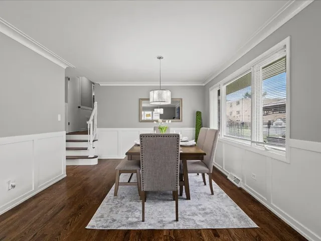 a dining room with furniture a chandelier and wooden floor