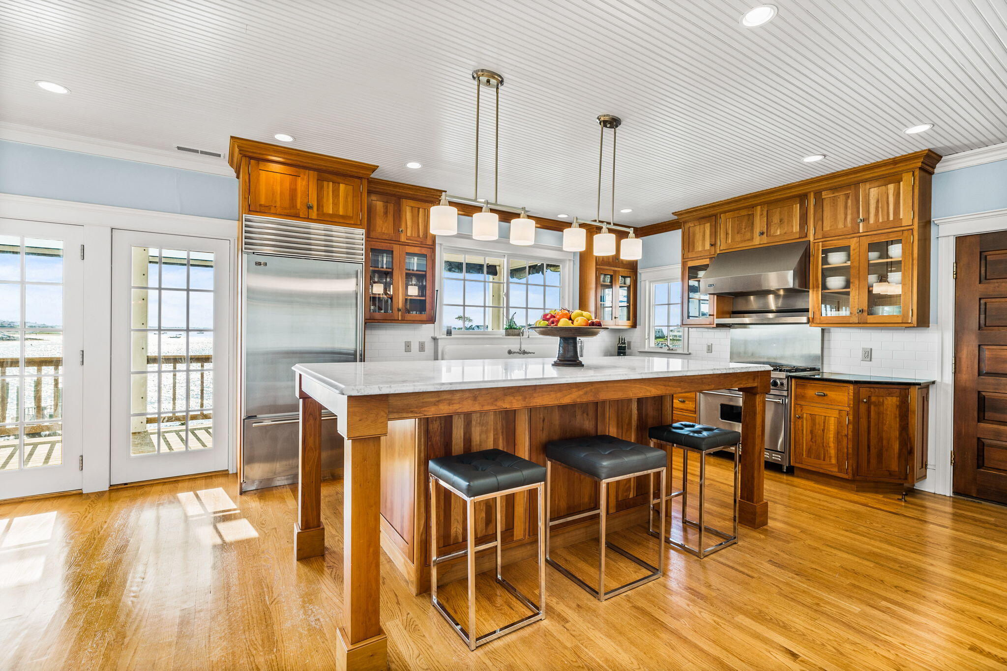 20 Bay Shore Road Hyannis, MA 02601 - Photo 11 of 42 a dining hall with stainless steel appliances granite countertop a kitchen island a stove a sink a refrigerator white cabinets a dining table and chairs with wooden floor