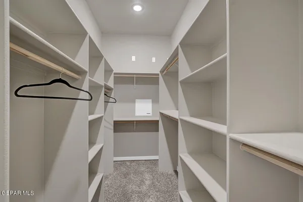 a bathroom with a granite countertop double vanity sink a mirror and a shower