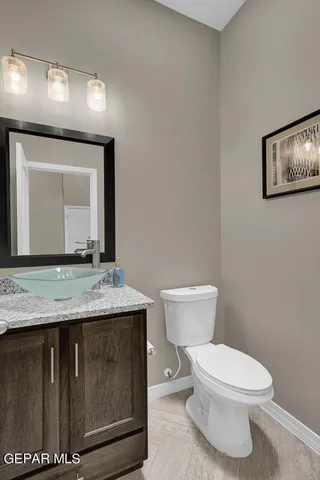 a bathroom with a granite countertop toilet a mirror and a sink
