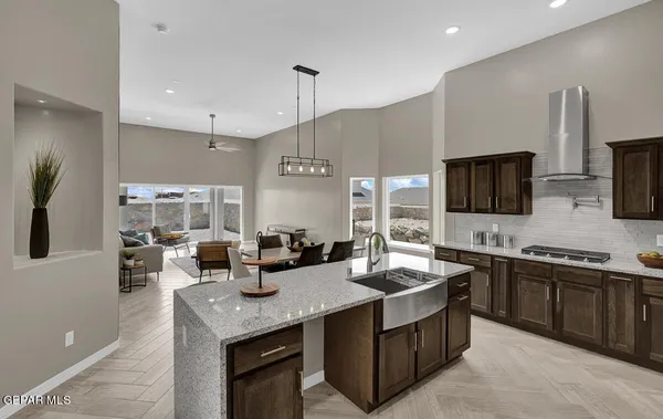 a kitchen with lots of counter furniture a sink and a refrigerator