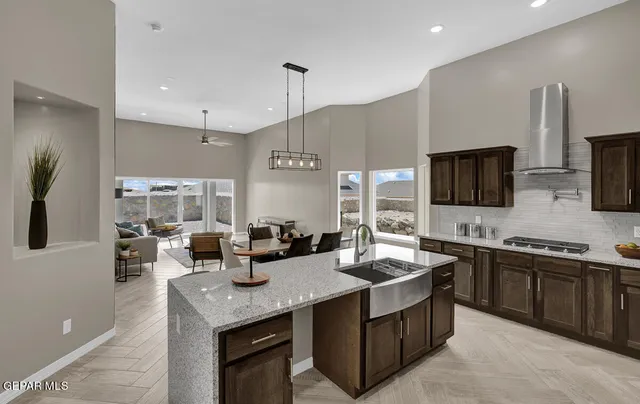 a kitchen with lots of counter furniture a sink and a refrigerator