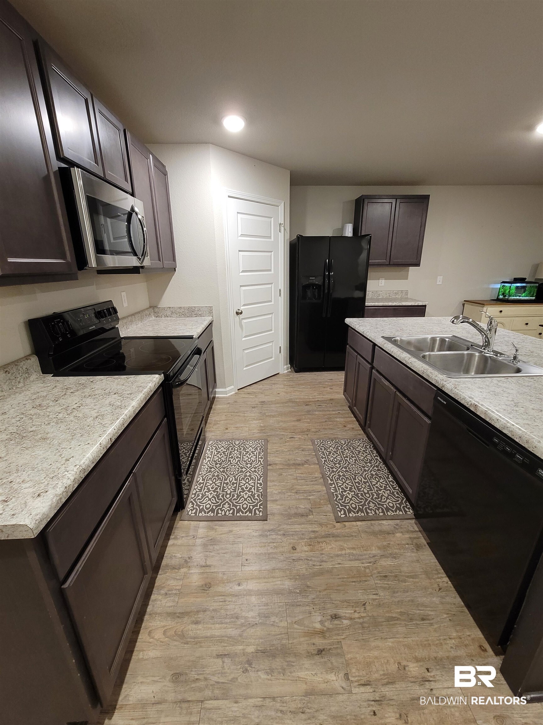 1305 Majesty Loop Foley, AL 36535 - Photo 10 of 24 Kitchen with black appliances, light countertops, light wood-style flooring, recessed lighting, and dark brown cabinets