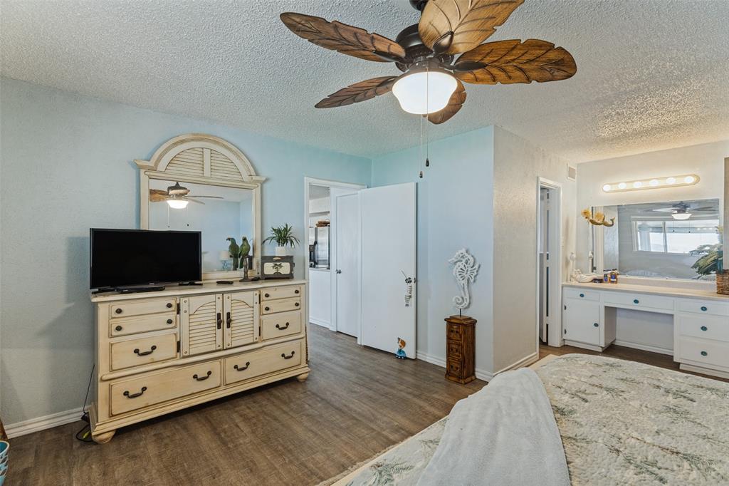 12960 Gantt Road East Azle, TX 76020 - Photo 11 of 26 Wood-finish flooring, built-in vanity with integrated lighting, and a ceiling fan with leaf-shaped blades