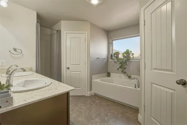 a bathroom with a granite countertop tub sink and mirror