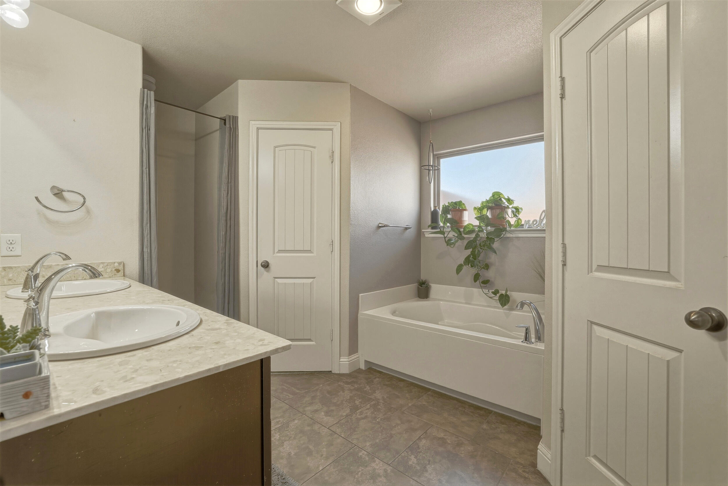 8808 Rochester Avenue Lubbock, TX 79424 - Photo 13 of 27 a bathroom with a sink a bathtub and a window